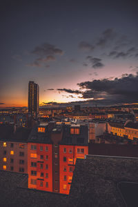 Illuminated cityscape against sky during sunset