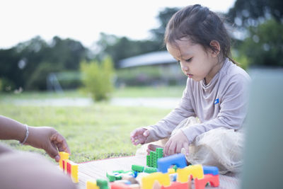 Side view of boy playing with toys at park