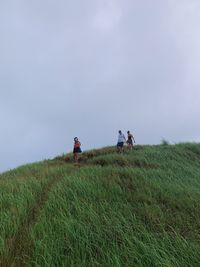 Low angle view of people on mountain against sky