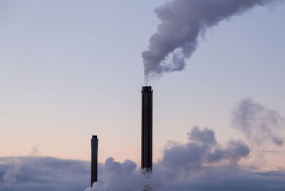 Smoke emitting from chimney against sky