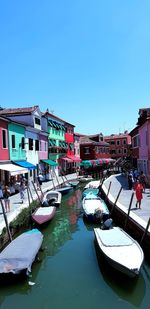 Boats moored in canal against buildings in city