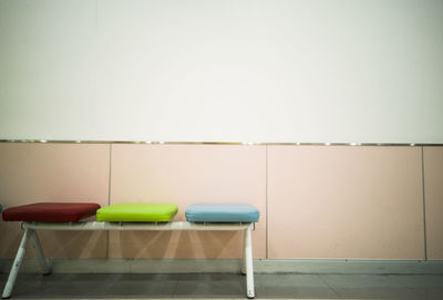 Empty chairs and table against wall