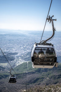 Overhead cable car over sea against sky