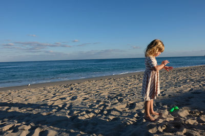 Full length of boy on beach against sky