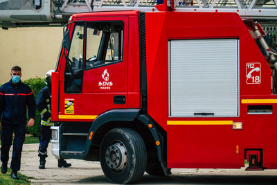 Rear view of man working at red bus