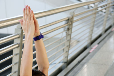 High section of man with hands clasped at balcony