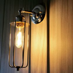 Close-up of illuminated light bulb against wall