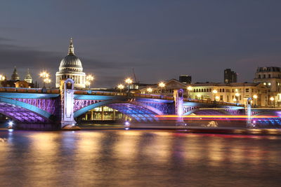 Scenic view of illuminated bridge over calm sea against cloudy sky