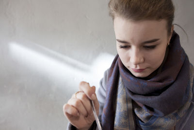 Portrait of woman wearing hat standing against wall