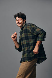 Portrait of young man standing against white background