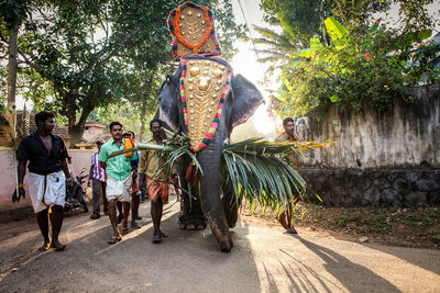 Rear view of people walking on footpath