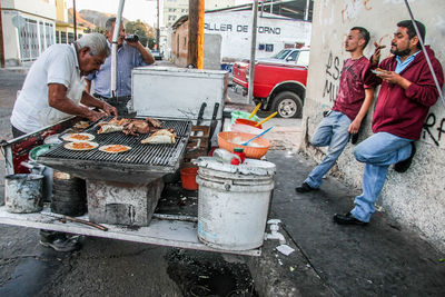 People working on barbecue grill
