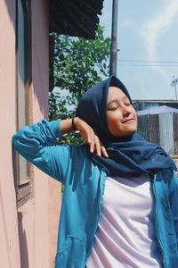 Young woman wearing headscarf while standing outdoors