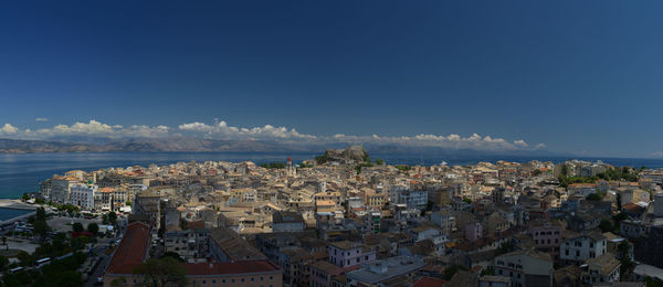 Aerial view of townscape against blue sky