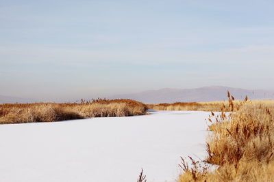 Scenic view of lake against sky during winter