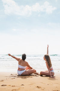 Women on beach against sky