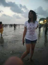 Woman standing on beach against sky