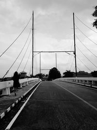 Rear view of man on bridge against sky