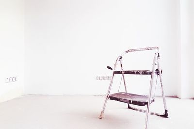 Old step ladder in white room