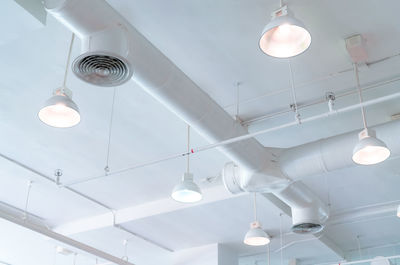 Low angle view of illuminated pendant lights hanging from ceiling