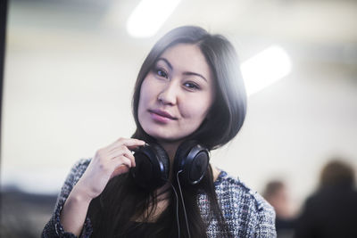 Young asia woman with paper in an office with headphone