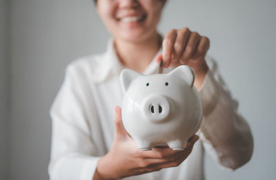 Midsection of woman holding piggy bank