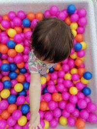 High angle view of girl playing with multi colored balls