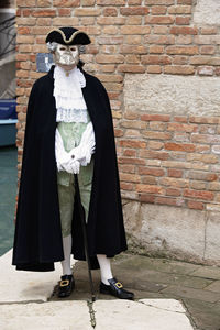 Man wearing mask against wall