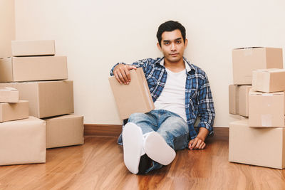 Portrait of mature man sitting on hardwood floor