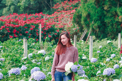 Woman standing by flowering plants