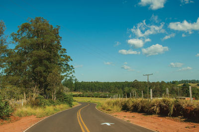 Countryside paved road on hilly landscape covered by meadows and trees, near pardinho. brasil.