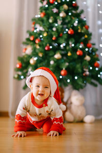 Portrait of cute girl playing with christmas tree