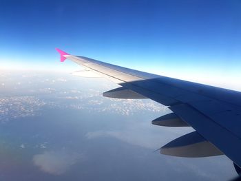 Close-up of airplane wing against sky