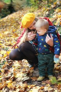 Mother and son in colorful forest during autumn