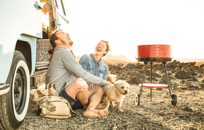 Happy couple with dog sitting on field