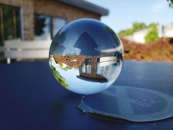 Close-up of crystal ball against building in city