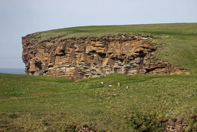 Stone wall on land against sky