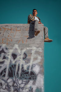 Portrait of young man standing against wall