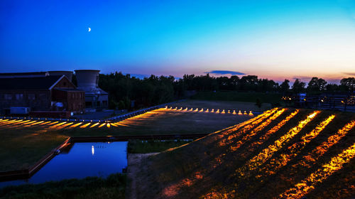 Scenic view of illuminated residential district against sky at night