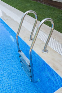 High angle view of empty chairs by swimming pool