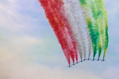 Low angle view of airplanes flying against sky