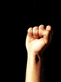 Close-up of human hand over black background