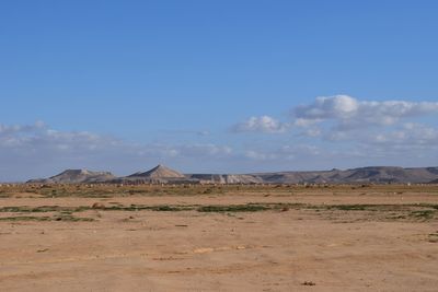 View of desert against cloudy sky