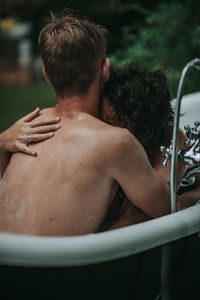 Rear view of man and woman looking at camera