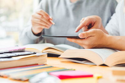 Midsection of man using mobile phone on table