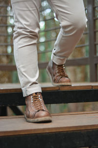 Low section of man standing on railing