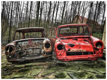 Abandoned car on field in forest
