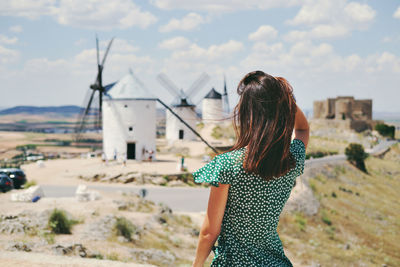 Rear view of woman standing against sky