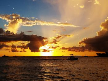 Scenic view of sea against dramatic sky during sunset