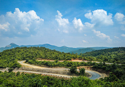 High angle view of road amidst trees against sky